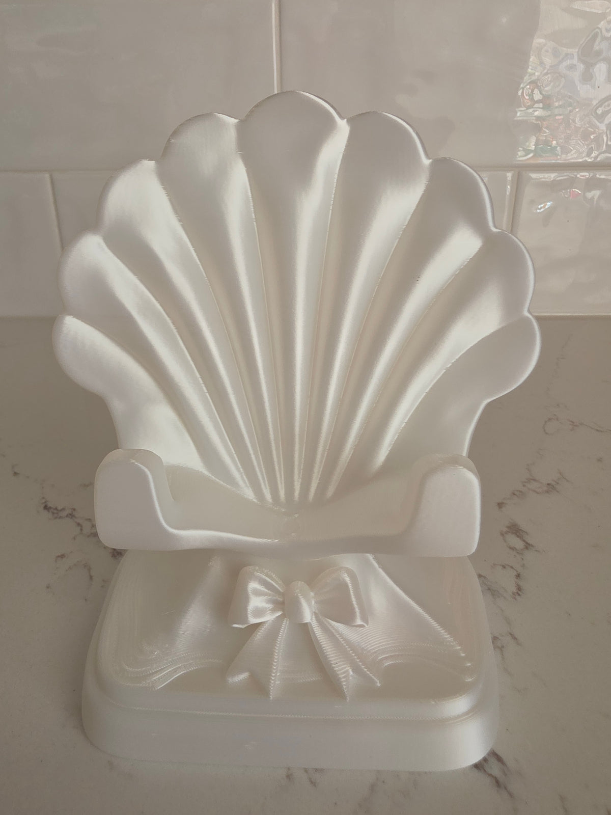 Soporte para teléfono en forma de concha con lazo impreso en 3D
